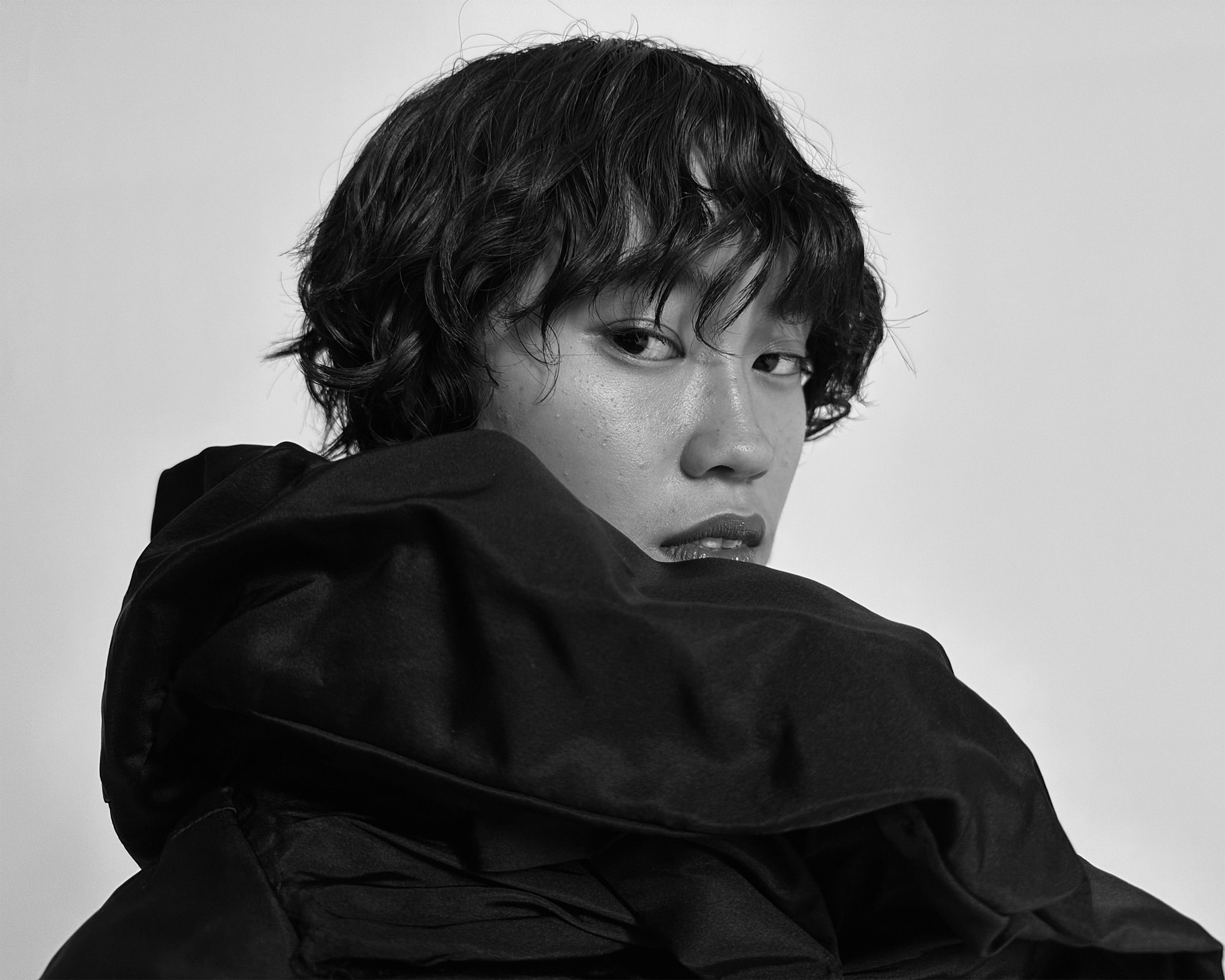 Photonic Engine iPhone 14 Pro Photo en noire et blanche d'un homme en veste noir molletonnée nous tournant le dos et regardant vers nous